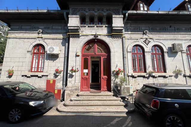 Casa DentalClinica din Strada Matei Voievod 112: ușa roșie în arc, treptele cu mozaic și ferestrele roșii