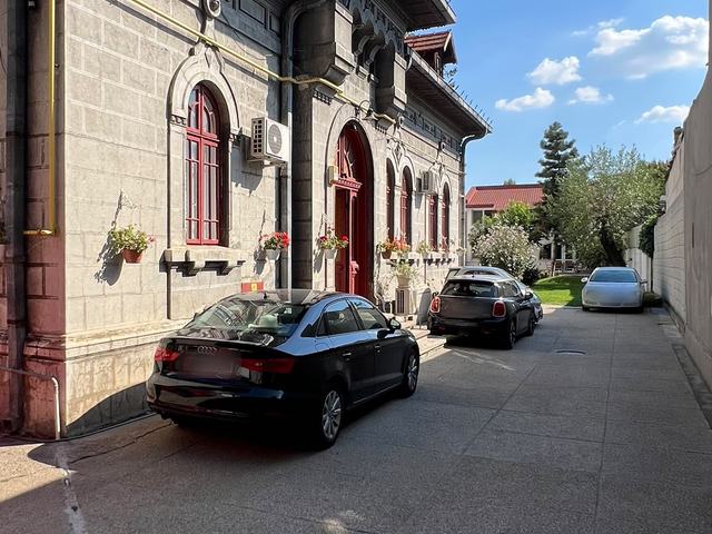 Curtea DentalClinica: aleea de-a lungul casei, cu ușa roșie de la intrare pe stânga