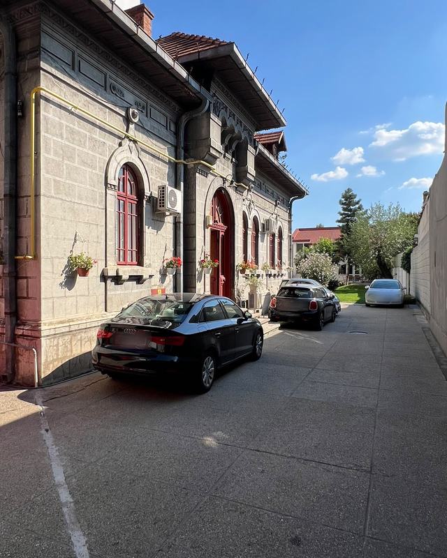Curtea DentalClinica: aleea de-a lungul casei, cu ușa roșie de la intrare pe stânga